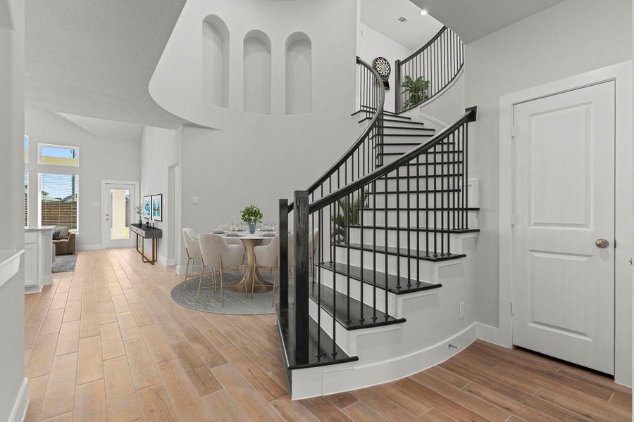 The grand curved staircase makes an unforgettable first impression! With its elegant wrought-iron railing and open two-story design, this architectural centerpiece brings luxury and drama to the San Marcos floor plan. *Photo Staged* The grand curved staircase makes an unforgettable first impression! With its elegant wrought-iron railing and open two-story design, this architectural centerpiece brings luxury and drama to the San Marcos floor plan. *Photo Staged*