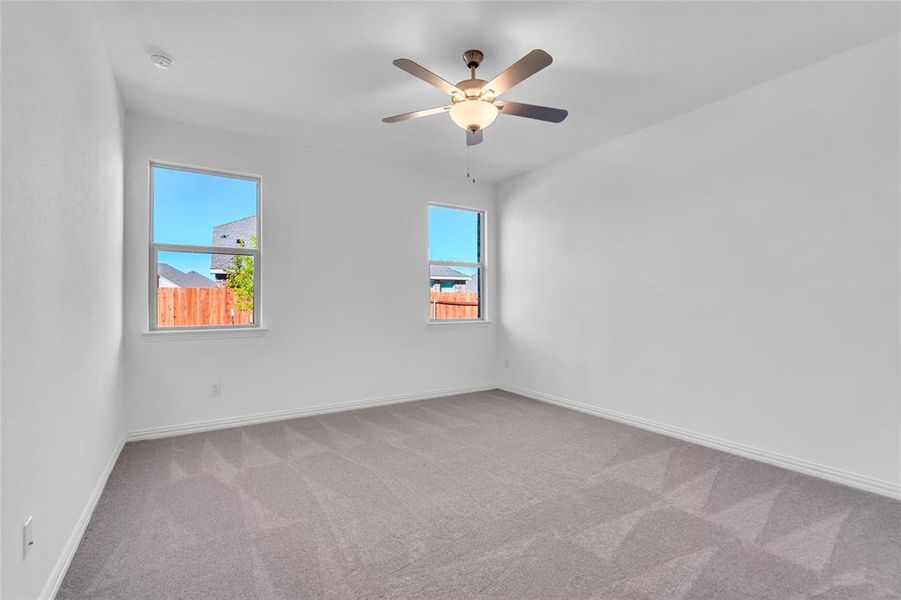 Spare room with light carpet, ceiling fan, and a healthy amount of sunlight