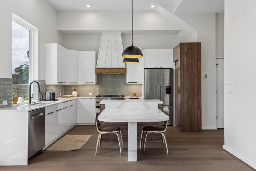 Contemporary kitchen featuring a spacious island, sleek cabinetry, designer lighting, and an open layout ideal for everyday living and entertaining. Contemporary kitchen featuring a spacious island, sleek cabinetry, designer lighting, and an open layout ideal for everyday living and entertaining.