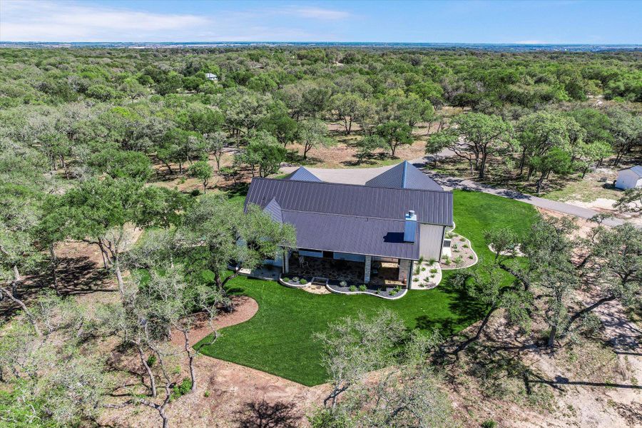 Aerial view of property and surrounding area featuring a heavily wooded area