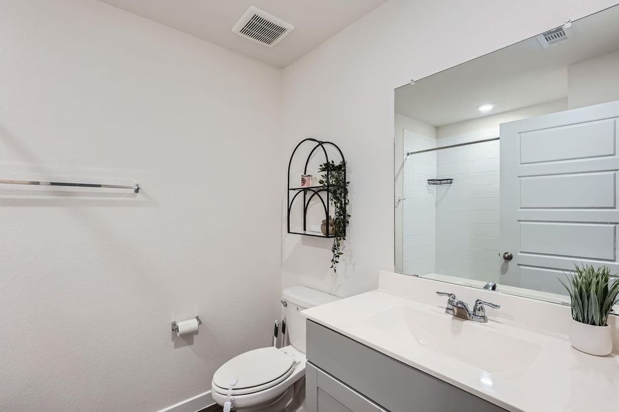 Full bath with visible vents, toilet, a shower, and vanity