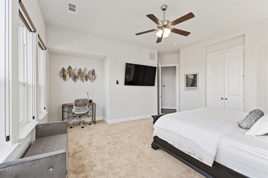 Carpeted bedroom with a closet and ceiling fan