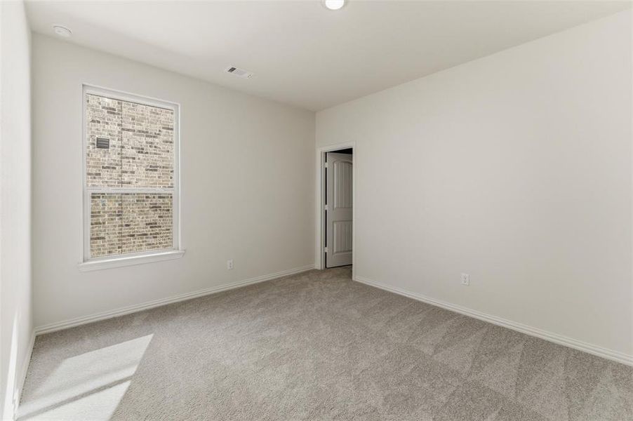 Unfurnished room featuring light carpet and baseboards