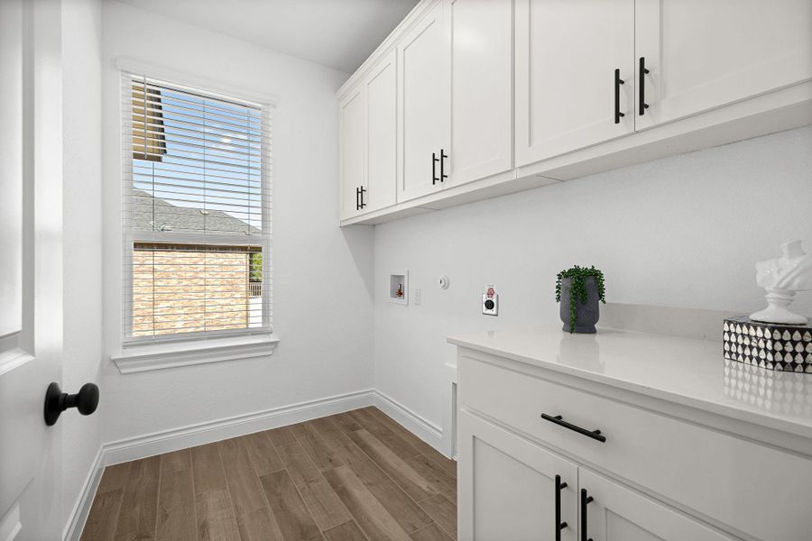 Laundry room featuring hookup for a washing machine, light wood-style floors, and cabinet space