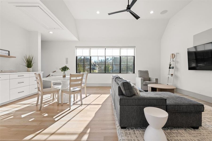 Guest house living and dining area featuring light wood-type flooring, ceiling fan, recessed lighting, and lofted ceiling