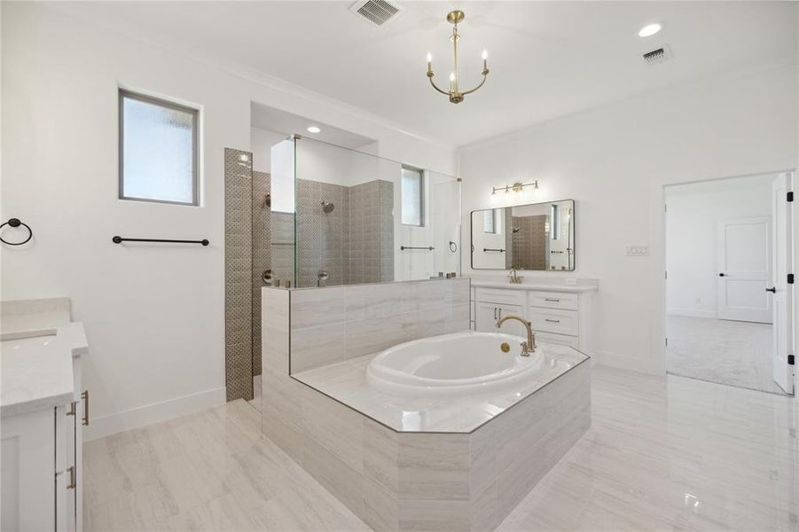 Bathroom featuring shower with separate bathtub and vanity