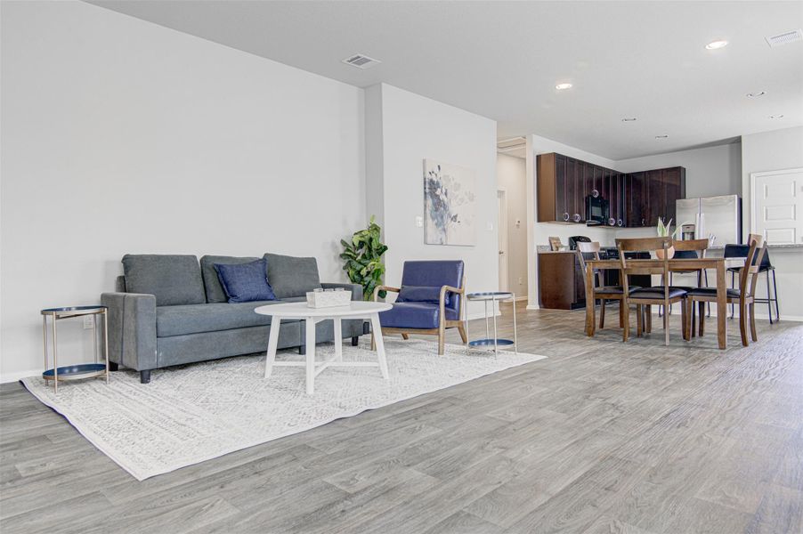 An open floorplan seamlessly connects the living and dining spaces to a modern kitchen. An open floorplan seamlessly connects the living and dining spaces to a modern kitchen.