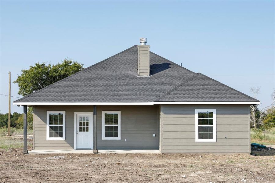 Rear view of property with roof with shingles and a chimney Rear view of property with roof with shingles and a chimney