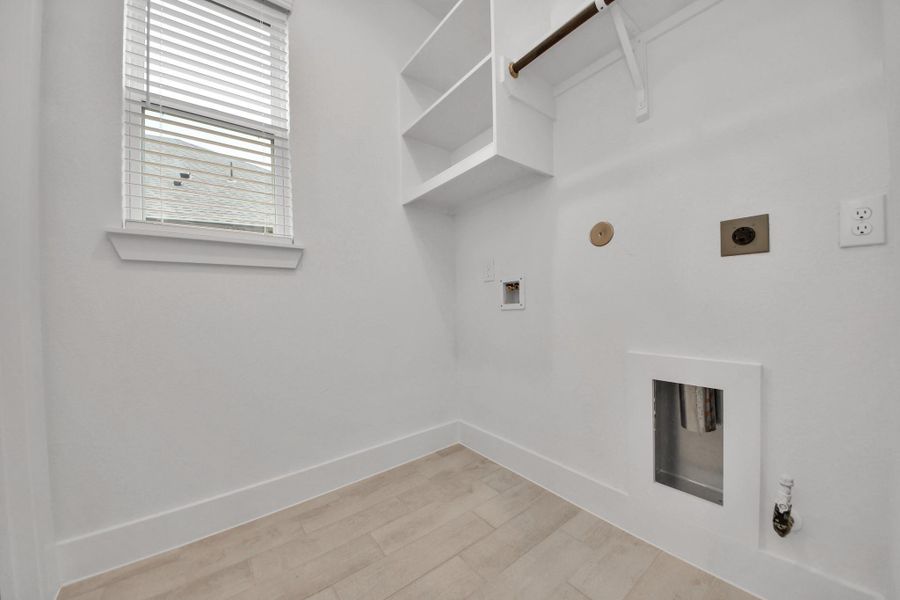 A perfect blend of functionality and comfort. Capture the essence of easy living with a first-floor laundry room, thoughtfully equipped with shelving for effortless organization. Both electric and gas connections available. Sample photo of completed home with similar floor plan. Actual colors and selections may vary. A perfect blend of functionality and comfort. Capture the essence of easy living with a first-floor laundry room, thoughtfully equipped with shelving for effortless organization. Both electric and gas connections available. Sample photo of completed home with similar floor plan. Actual colors and selections may vary.