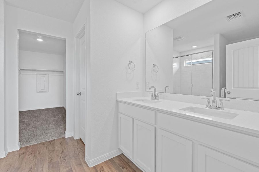 Full bathroom featuring a spacious closet, double vanity, a shower stall, light wood finished floors, and recessed lighting Full bathroom featuring a spacious closet, double vanity, a shower stall, light wood finished floors, and recessed lighting
