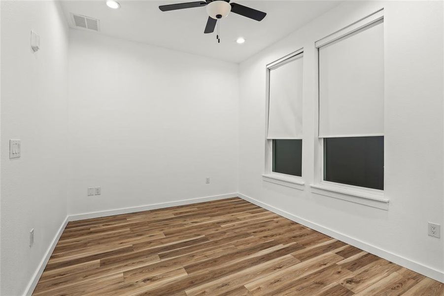 Unfurnished room featuring wood finished floors, a ceiling fan, and recessed lighting