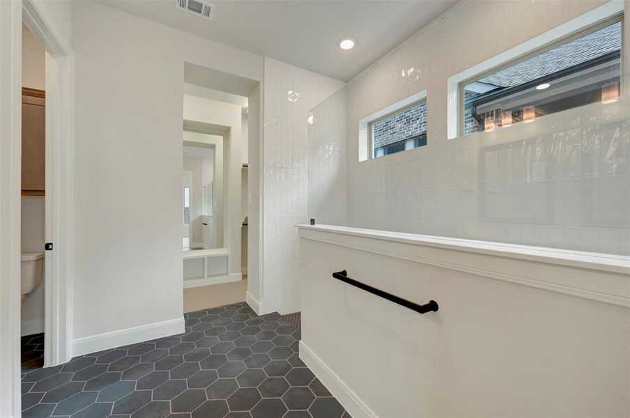 Hallway featuring dark tile patterned flooring and recessed lighting