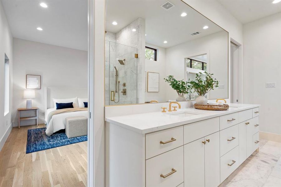 Ensuite bathroom featuring double vanity, a shower stall, recessed lighting, and wood finished floors Ensuite bathroom featuring double vanity, a shower stall, recessed lighting, and wood finished floors