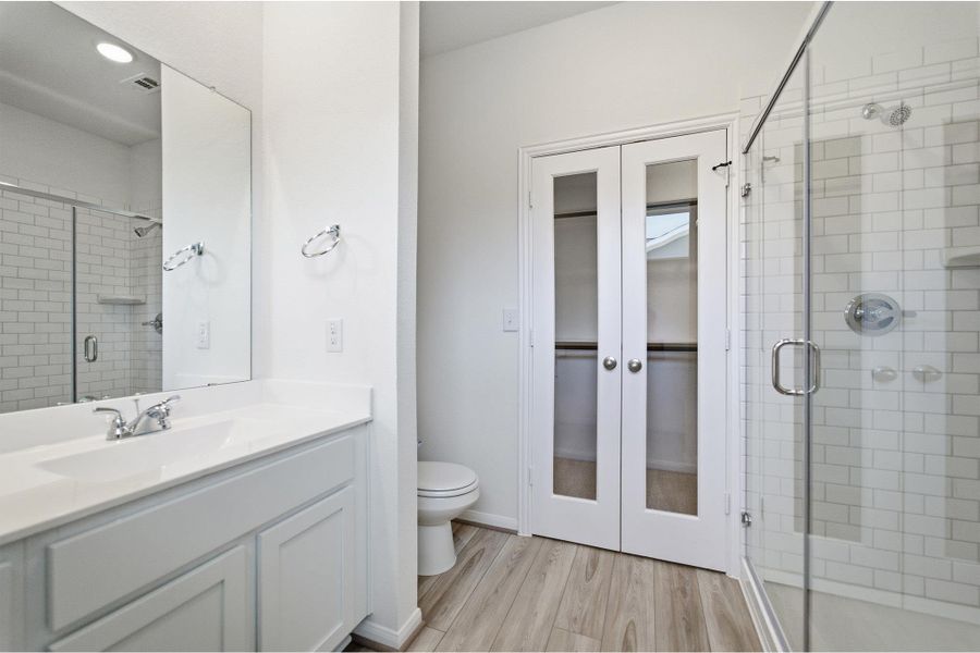 Bathroom with vanity, a stall shower, light wood-style flooring, and a closet Bathroom with vanity, a stall shower, light wood-style flooring, and a closet
