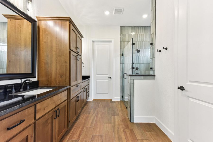 Full bath with vanity, a shower stall, light wood-style floors, and recessed lighting