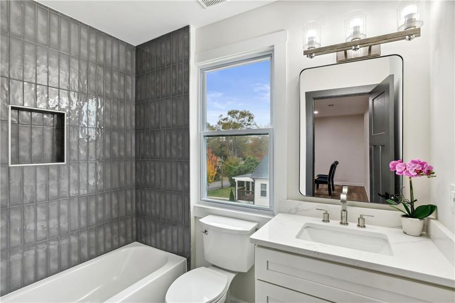 Full bathroom featuring tiled shower / bath, toilet, and vanity