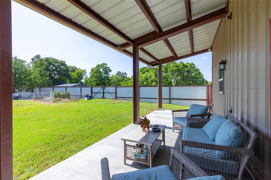 Covered patio featuring a concrete slab and metal roof structure Covered patio featuring a concrete slab and metal roof structure