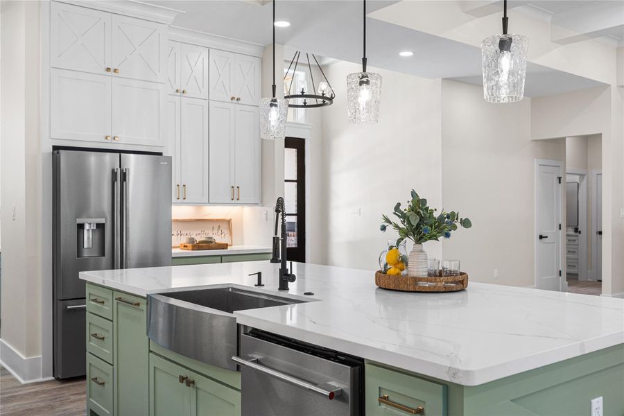 This Homes Features Two Prep Areas with this Large Stainless Steal Farm Style Sink and a Second Sink in the Butler's Pantry, with Black Accent Fixtures and Gold hardware for a Designer Look.