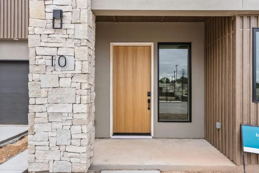 Entrance to property with stone siding and stucco siding