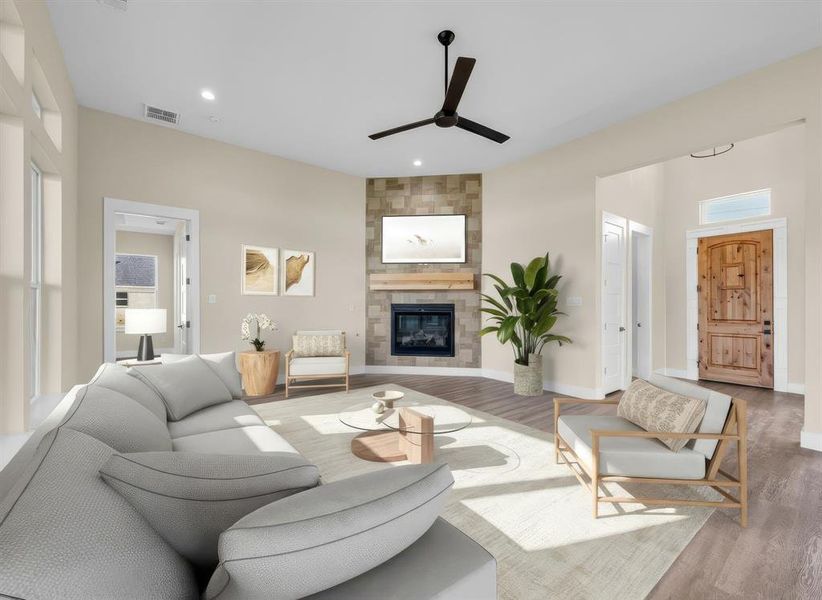 Staged Living room featuring ceiling fan, wood finished floors, a tiled fireplace, and recessed lighting Staged Living room featuring ceiling fan, wood finished floors, a tiled fireplace, and recessed lighting