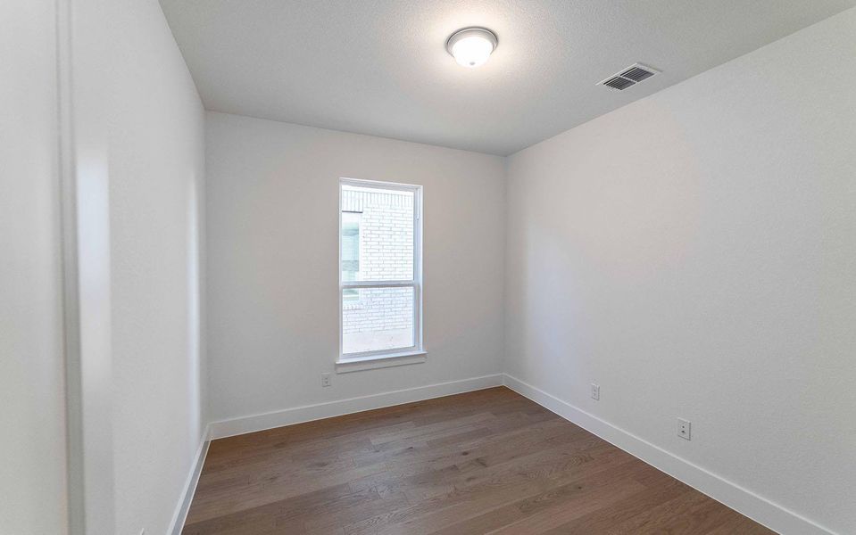 Spare room featuring wood finished floors and baseboards