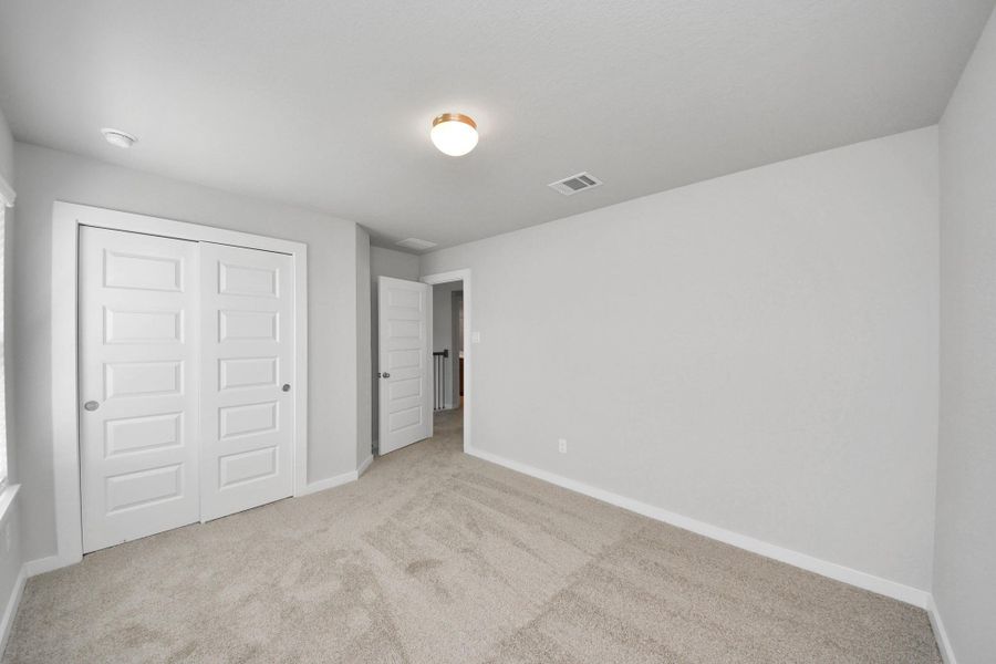 Generously sized secondary bedrooms featuring spacious closets, soft and inviting carpeting underfoot, large windows allowing plenty of natural light, and the added touch of privacy blinds for your personal retreat. Sample photo of completed home with similar floor plan. Actual colors and selections may vary.