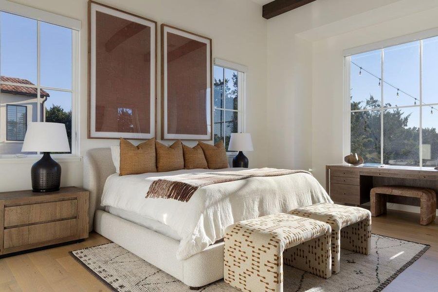 Bedroom featuring light wood-style floors and beamed ceiling