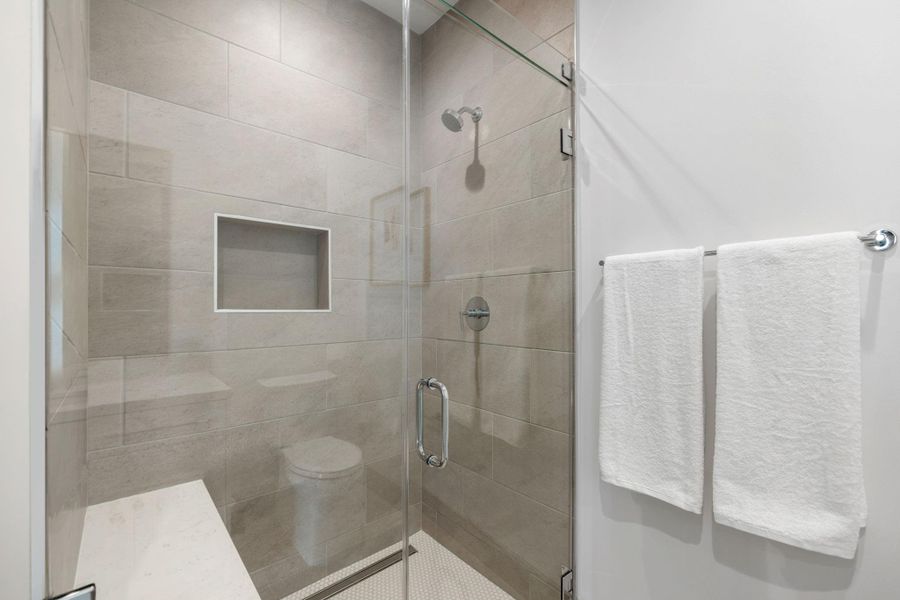 Alternate view of the guest bathroom featuring a glass enclosed walk-in showe. Photos are of a similar unit with the same floor plan