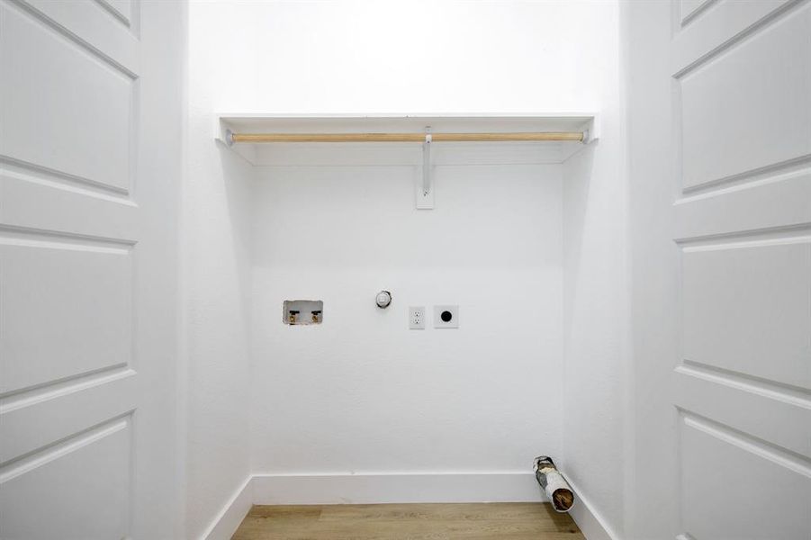 Laundry area with hookup for a gas dryer, light wood-style floors, washer hookup, and hookup for an electric dryer