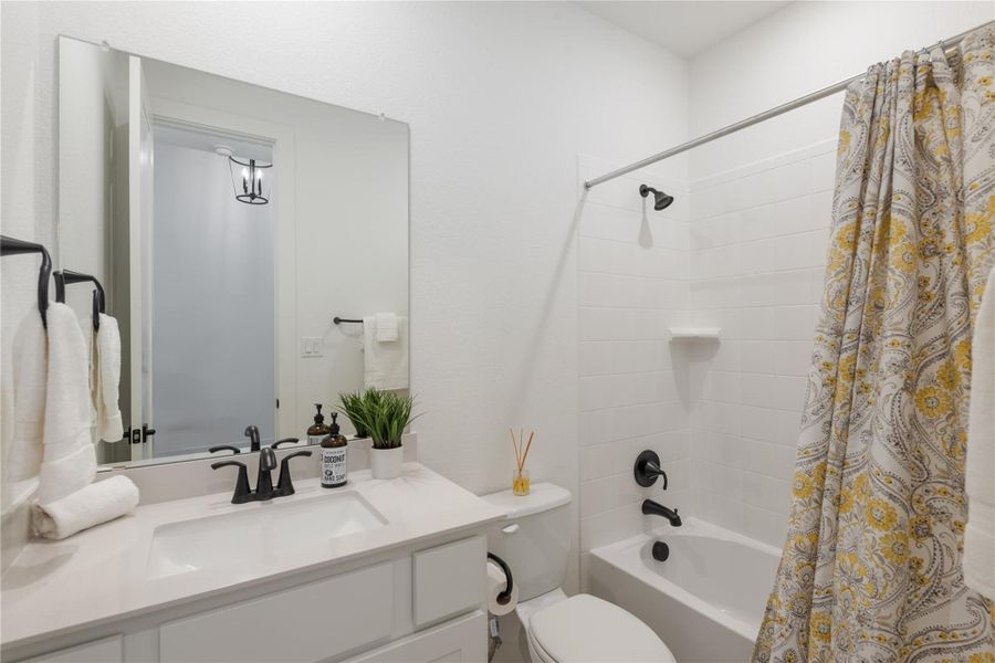 A pristine bath features modern fixtures and ample counter space. A pristine bath features modern fixtures and ample counter space.