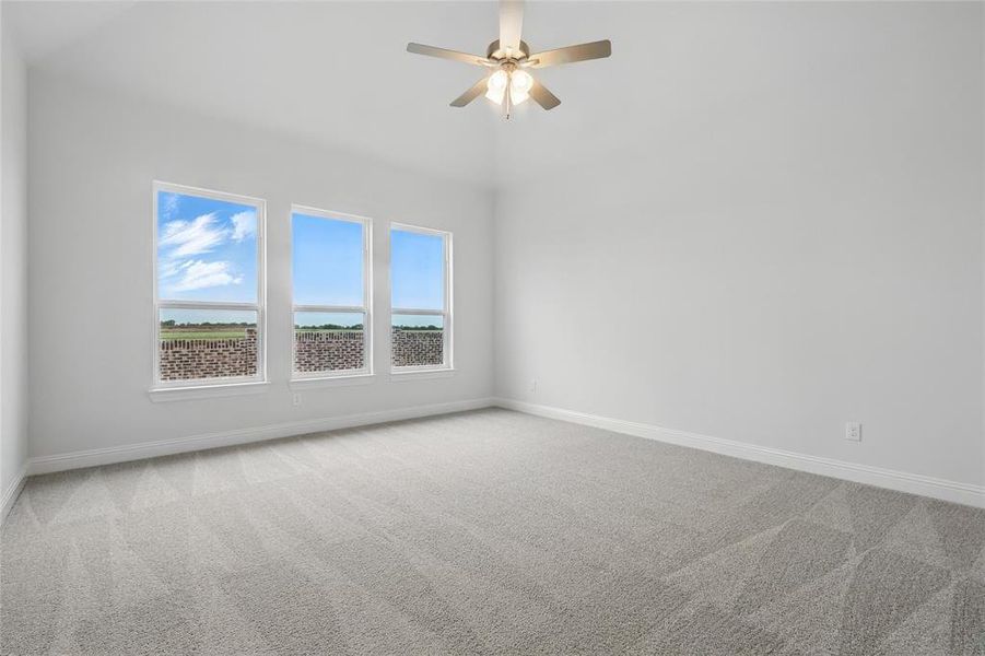 Empty room with carpet floors, a ceiling fan, and baseboards
