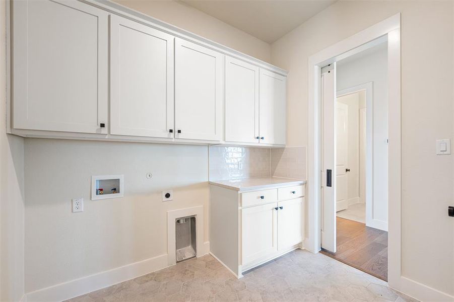 Laundry room featuring hookup for a washing machine, electric dryer hookup, and cabinet space