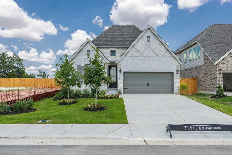 View of front of home with driveway, brick siding, an attached garage, and roof with shingles