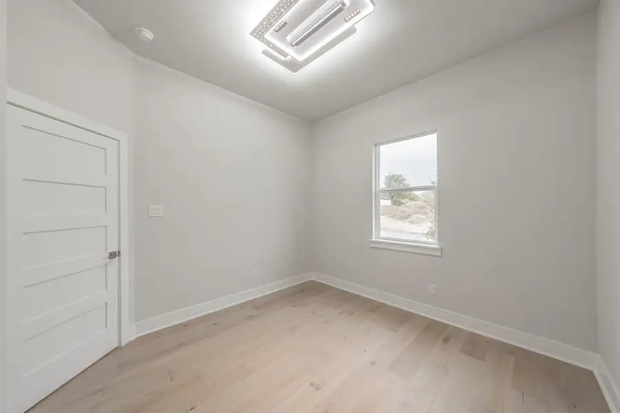 Spare room featuring light wood-style floors and baseboards