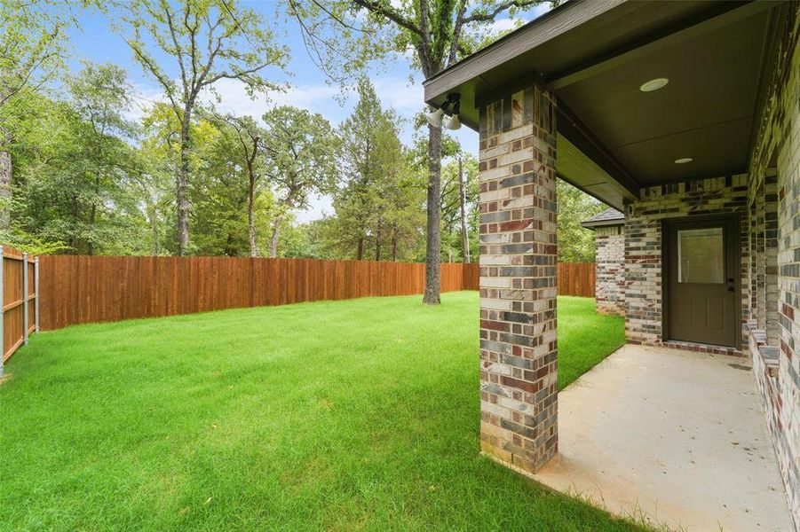 Expansive backyard featuring a lush lawn and wood privacy fencing Expansive backyard featuring a lush lawn and wood privacy fencing