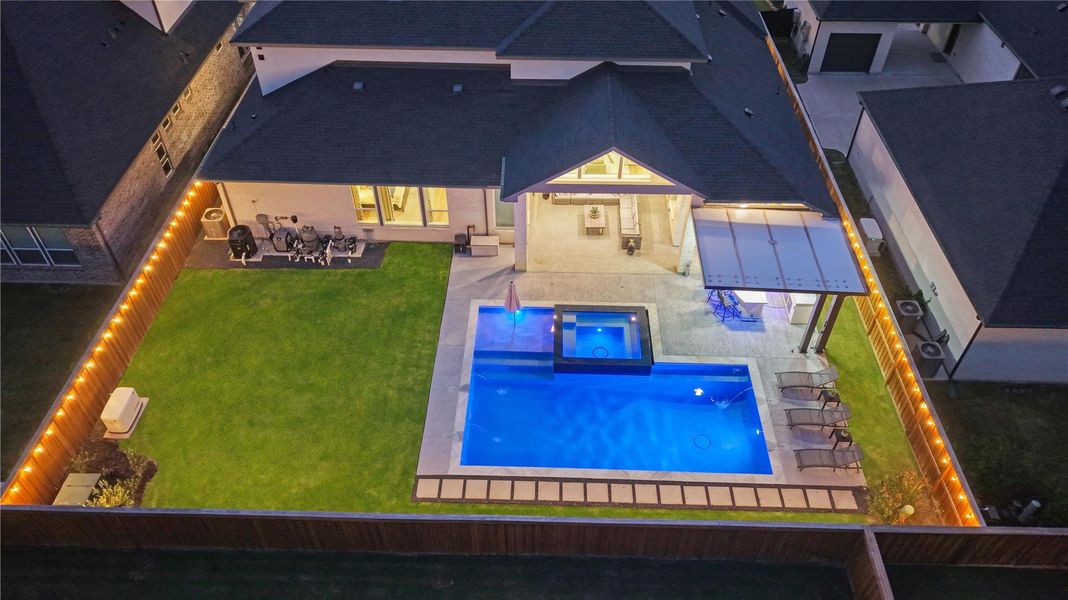 Beautifully illuminated at night, the backyard creates a warm, inviting ambiance that's perfect for evening entertaining or relaxing under the stars.