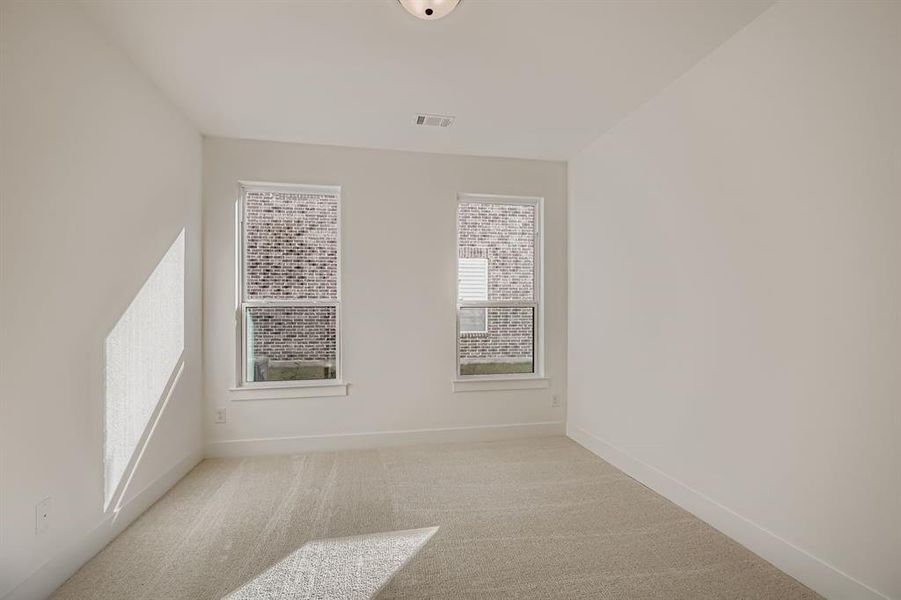 Spare room featuring light colored carpet and baseboards