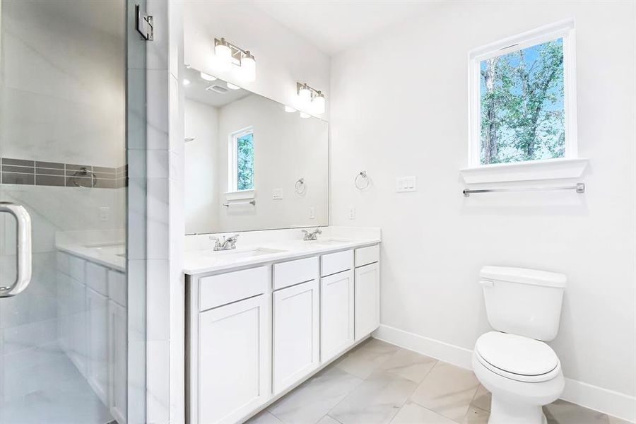 View of Primary bathroom with double sinks and a beautiful shower.