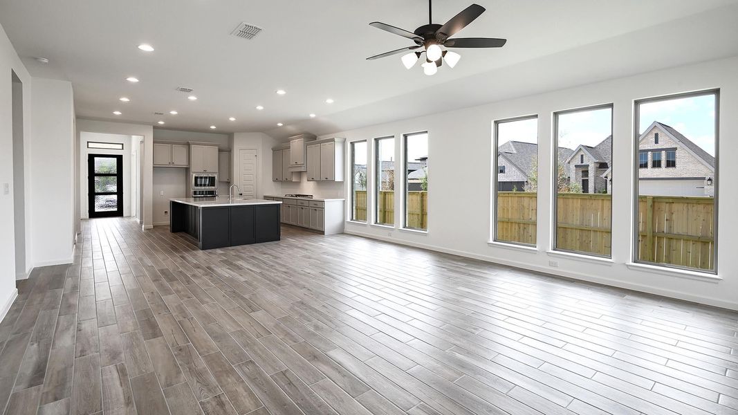 Kitchen with open floor plan, recessed lighting, an island with sink, gray cabinets, and dark wood-style flooring Kitchen with open floor plan, recessed lighting, an island with sink, gray cabinets, and dark wood-style flooring