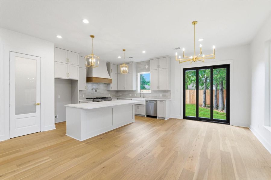 Hello, gorgeous. A massive 8.5-foot island offers additional seating alongside the spacious dining area, with both spaces beautifully accented by gold pendant and chandelier lighting.