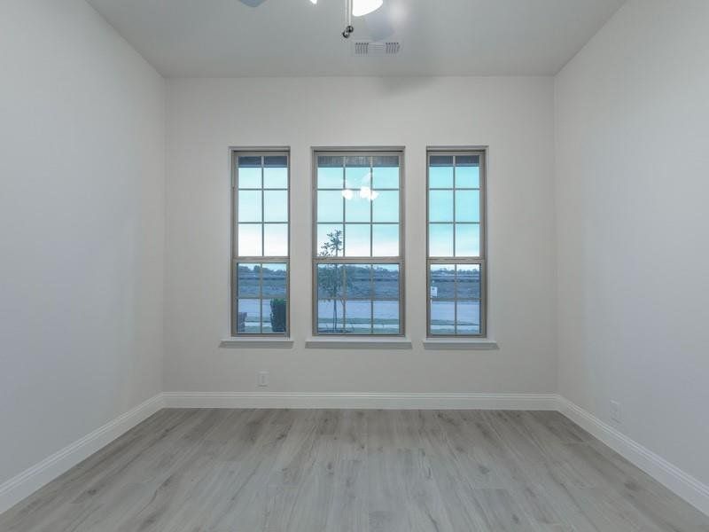 Spare room with light hardwood / wood-style floors and ceiling fan