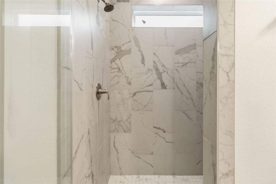Custom walk-in shower with bench seat in primary suite