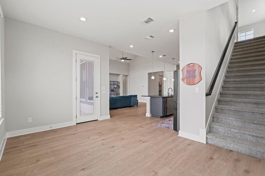 Unfurnished living room featuring light wood finished floors, recessed lighting, stairway, and a ceiling fan Unfurnished living room featuring light wood finished floors, recessed lighting, stairway, and a ceiling fan