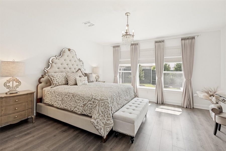 High ceilings and tall windows frame this light-filled suite featuring premium wide-plank wood flooring.