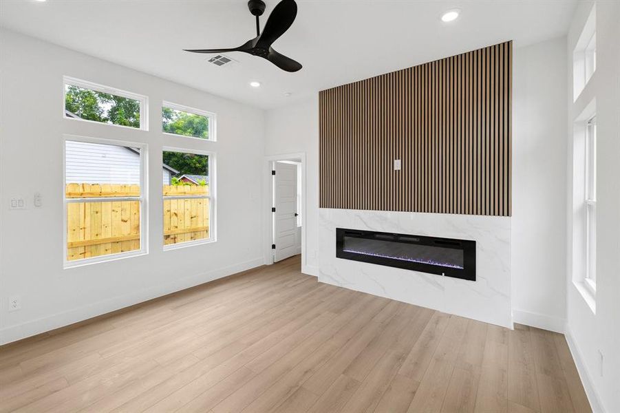 Unfurnished living room featuring a fireplace, ceiling fan, wood finished floors, and recessed lighting