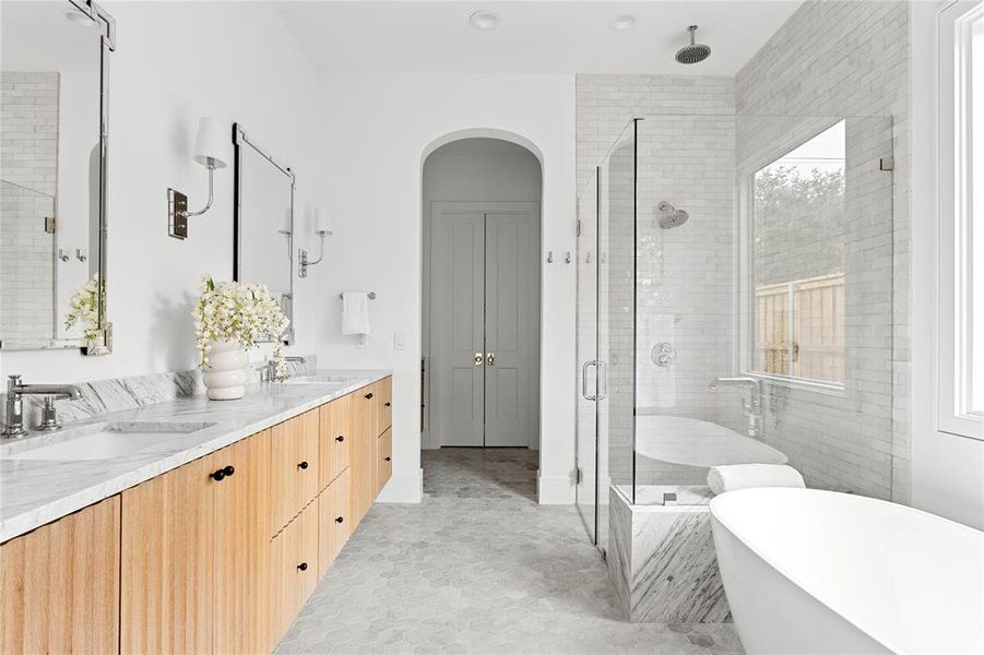 Full bathroom featuring double vanity, a soaking tub, and a stall shower