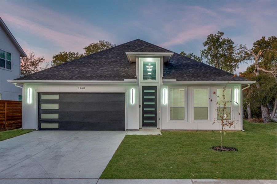 View of front of home with a yard and a garage