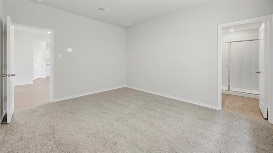 Spare room with light carpet and baseboards Spare room with light carpet and baseboards