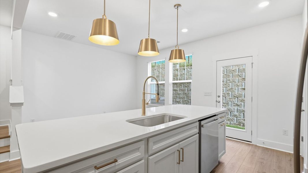Notable kitchen space with elegant pendant lighting and a large island perfect for entertaining
