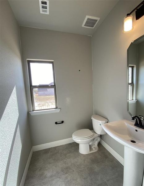 Powder bath downstairs for guests with window for natural light